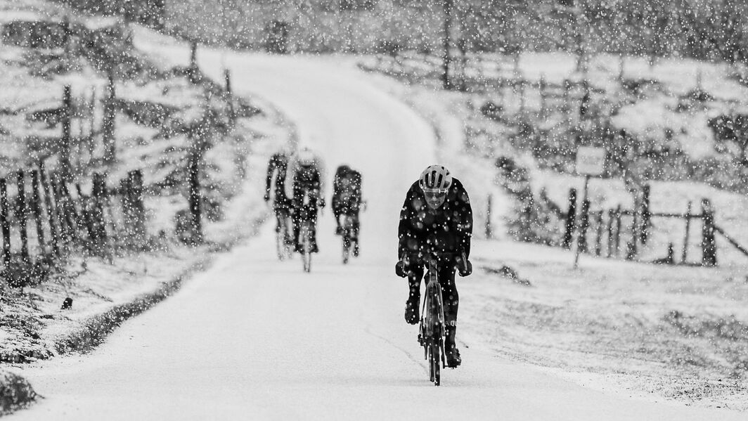 Ciclistas enfrentam a queda de neve durante o percurso