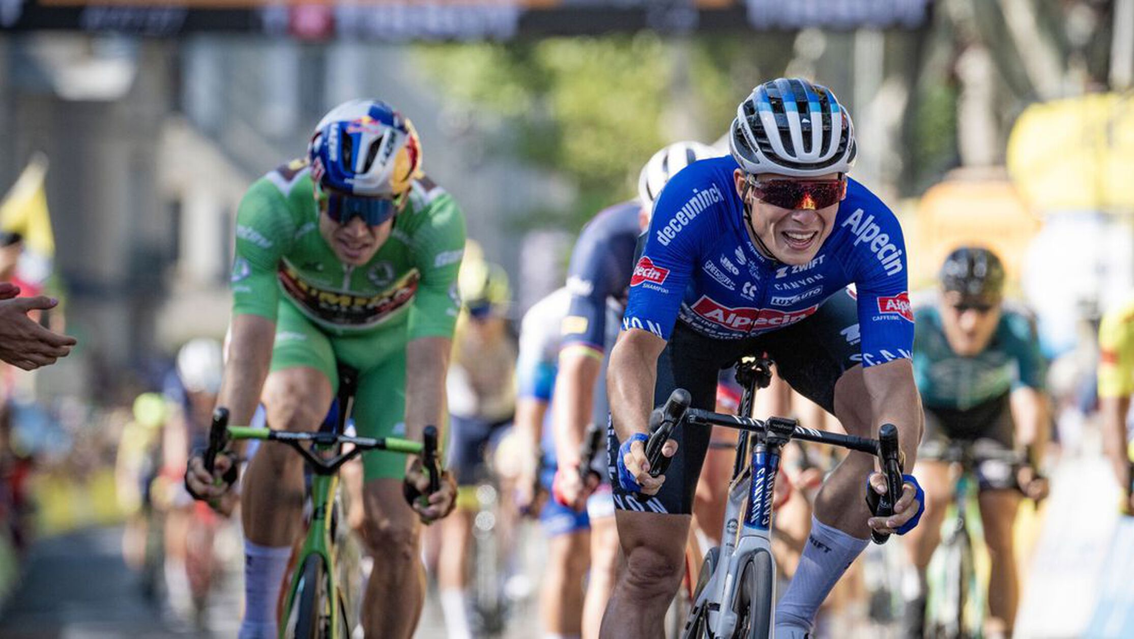 Two pro cyclists head to the finish line at Tour de France 2024, one riding a Canyon bike, showcasing grit