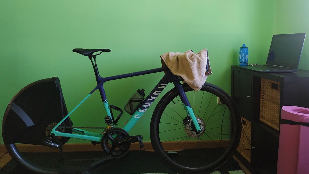 Canyon Ultimate set up on a turbo trainer with a laptop in front of it. The Zwift home screen is on the laptop.