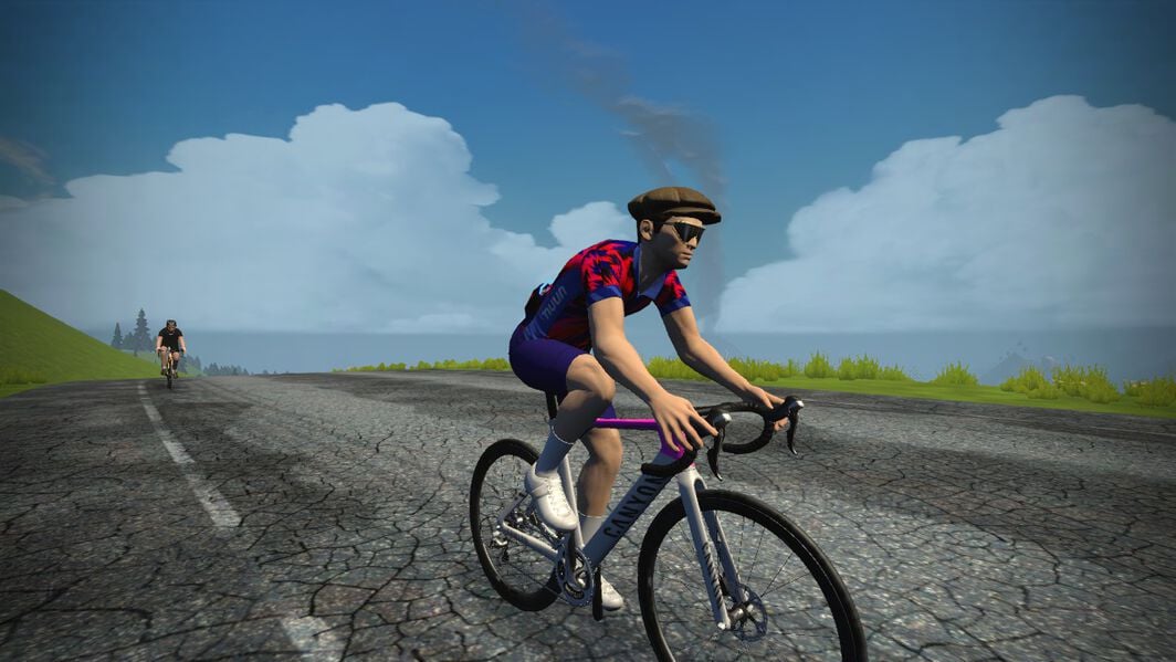 A Zwift rider riding a white and purple Zwift Canyon Aeroad along the road in Watopia.