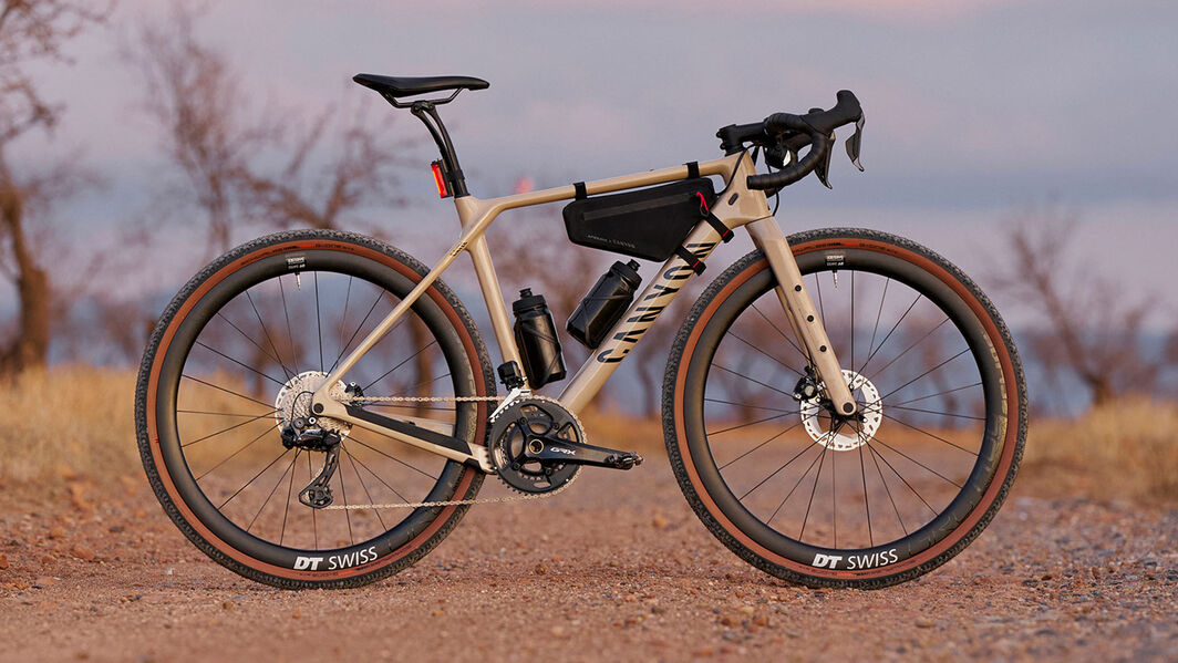 フレームバッグとボトル2本などを積んだバイクパッキング用セットアップのグラベルバイクCanyon Grizl。埃っぽいトレイルでの走りをDT Swissのホイールが支えます。