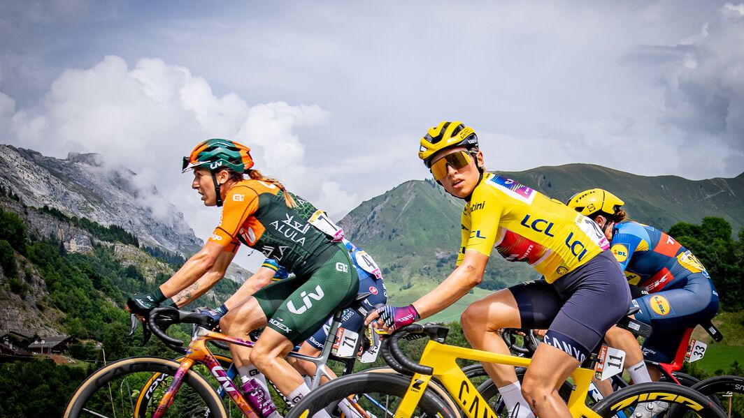 Kasia Niewiadoma in the yellow jersey riding her Canyon bike in the Tour de France Femmes as a leader, surrounded by competitors.