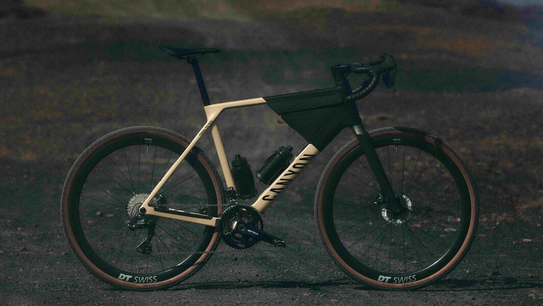 Canyon Grailグラベルバイク - 過酷な道でも使えるアドベンチャー向けのセットアップ 長距離ライドやオフロードのトレイルを進むアドベンチャーライドに特化した設計のCanyon Grailグラベルバイク。フレームバッグとボトルを装備。